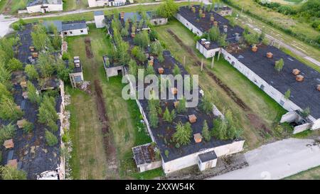 Fotografia con drone di una vecchia fabbrica di polli abbandonata al coperto durante il giorno nuvoloso estivo Foto Stock