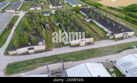 Fotografia con drone di una vecchia fabbrica di polli abbandonata al coperto durante il giorno nuvoloso estivo Foto Stock