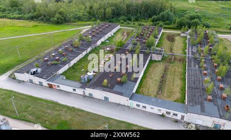 Fotografia con drone di una vecchia fabbrica di polli abbandonata al coperto durante il giorno nuvoloso estivo Foto Stock