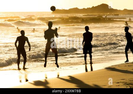 Salvador, Bahia, Brasile - 6 dicembre 2019: Si vedono persone che giocano a Beach Soccer al tramonto sul bordo della spiaggia di Farol da barra. Salvador, Bahia. Foto Stock