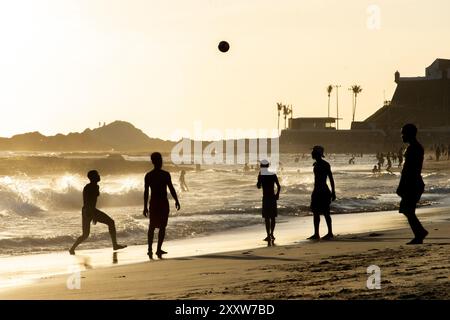 Salvador, Bahia, Brasile - 6 dicembre 2019: Si vedono persone che giocano a Beach Soccer al tramonto sul bordo della spiaggia di Farol da barra. Salvador, Bahia. Foto Stock