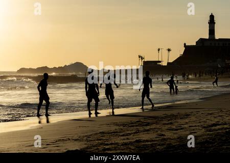 Salvador, Bahia, Brasile - 6 dicembre 2019: Le persone giocano a Beach Soccer al tramonto sulla spiaggia di Farol da barra nella città di Salvador, Bahia. Foto Stock