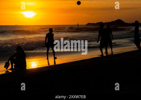 Salvador, Bahia, Brasile - 6 dicembre 2019: Si vedono persone che giocano a Beach Soccer al tramonto sul bordo della spiaggia di Farol da barra. Salvador, Bahia. Foto Stock