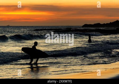 Salvador, Bahia, Brasile - 6 dicembre 2019: Surfista viene visto lasciare la spiaggia di Farol da barra nella città di Salvador, Bahia. Foto Stock