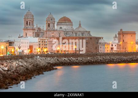 Vista delle cupole e delle torri della Cattedrale di Santa Croce sul terrapieno della città la mattina presto. Cadice. Spagna. Andalusia. Foto Stock