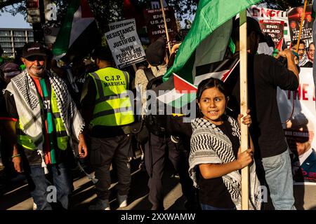 Chicago, Stati Uniti. 21 agosto 2024. Una giovane ragazza che indossa un keffiyeh ondeggia la bandiera palestinese durante una protesta al di fuori della Convention Nazionale Democratica a Union Park a Chicago, Illinois, mercoledì 21 agosto 2024. Migliaia di attivisti filo-palestinesi hanno partecipato alle marce e alle proteste tenutesi durante la settimana del DNC per protestare contro il sostegno degli Stati Uniti a Israele e chiedere un cessate il fuoco alla guerra a Gaza. Crediti: SIPA USA/Alamy Live News Foto Stock