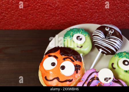 Piatto di deliziose noci di Halloween assortite su sfondo di legno nero Foto Stock