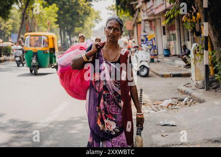 Ahmenabad, India - 20 ottobre 2023: Si vede lavorare una povera donna di strada con sari della classe e casta indiana inferiore, conosciuta come dalit o intoccabile Foto Stock