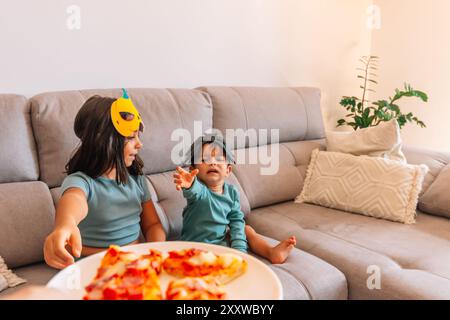 Bambini in costumi di halloween che mangiano pizza Foto Stock