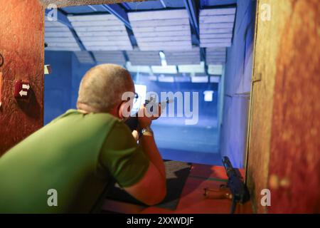 Uomo con pistola nel campo di tiro Foto Stock