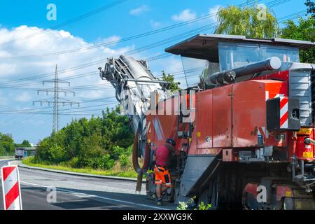 Fresatrice stradale per la rimozione dell'asfalto vecchio. Costruzione di strade Foto Stock