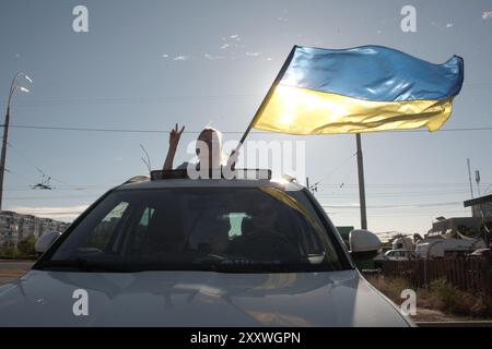 Non esclusiva: KIEV, UCRAINA - 23 AGOSTO 2024 - Una donna con bandiera Ucraina si erge sul tetto durante la 10a gara con la bandiera Ucraina in Foto Stock