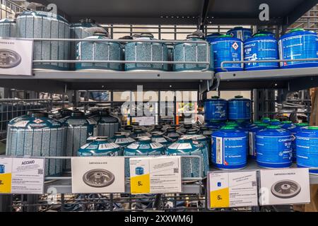 Italia - luglio 30, 2024: Lattine di gas propano butano per campeggi stufa a gas esposte sugli scaffali in vendita nel negozio italiano Decathlon Foto Stock