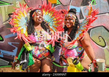 Londra, Regno Unito. 26 agosto 2024. Gli artisti di una band mas posano nella loro area di riscaldamento. Il Carnevale di Notting Hill di lunedì vede la principale processione di bande mas, batteristi e gruppi caraibici e sudamericani di salsa, Samba e Soca. I rivelatori celebrano il fine settimana festivo partecipando o guardando lungo il percorso del carnevale, presso impianti sonori, bancarelle e luoghi durante il secondo dei due giorni di festeggiamenti del Carnevale di Notting Hill. Crediti: Imageplotter/Alamy Live News Foto Stock