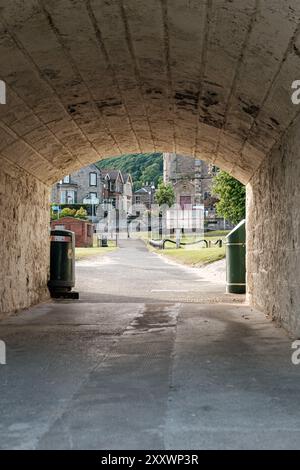 BURNTISLAND, FIFE, SCOZIA, Regno Unito - 11 GIUGNO 2024: Un pittoresco sentiero del villaggio rivela affascinanti edifici in pietra e vegetazione lussureggiante. Foto Stock