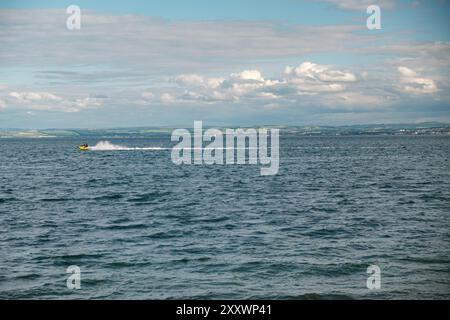 BURNTISLAND, FIFE, SCOZIA, Regno Unito - 11 GIUGNO 2024: Un motoscafo scivola attraverso Firth of Forth, lasciando dietro di sé una scia mentre si muove rapidamente. Foto Stock