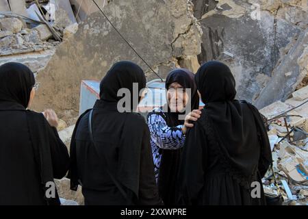 Khiam, Libano. 26 agosto 2024. Le donne libanesi ispezionano le distruzioni causate dagli scioperi israeliani nel villaggio di confine libanese meridionale di Khiam durante uno scontro tra Hezbollah filo-iraniano e le forze israeliane. Credito: STR/dpa/Alamy Live News Foto Stock