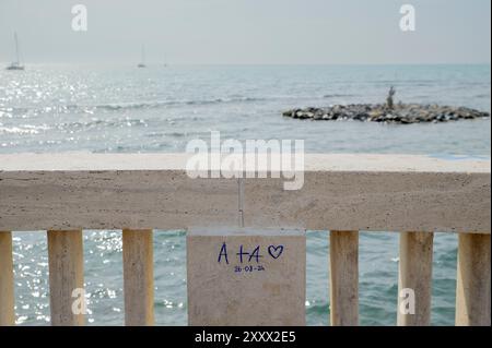 Roma, Italia. 26 agosto 2024. Due amanti lasciarono tracce del loro passaggio sul marmo del molo di Ostia a Roma. Massimo Muzzarelli, presidente di Federbalneari e proprietario di Sporting Beach, chiuso dal comune per tasse non pagate, effettua una prima valutazione della stagione balneare che non si è ancora conclusa e segnala un calo di almeno il 40% delle presenze alle spiagge del mare di '' ‹'''‹Roma. Secondo il presidente del Partito Democratico del 10° Municipio, Mario Falconi, il declino non è così drastico e sottolinea che va tenuto presente che le spiagge di Ostia partono da una situa Foto Stock