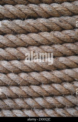 Uno sfondo full frame di spessa fune di spedizione strettamente avvolta insieme e realizzate in fibre naturali durevoli come la iuta con orientamento verticale wi Foto Stock