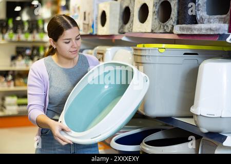 Donna gatto proprietario scelta vassoio di plastica lettiera in negozio di animali domestici Foto Stock