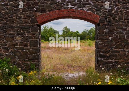 Una porta aperta in un muro di vecchie rovine di miniere. Foto Stock