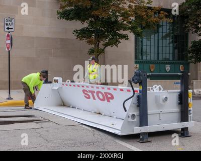 I lavoratori installano una barricata retrattile su Calumet Avenue alla 21st Street vicino a McCormick Place in preparazione della Convenzione Nazionale Democratica, agosto 2024. Chicago, Illinois Foto Stock