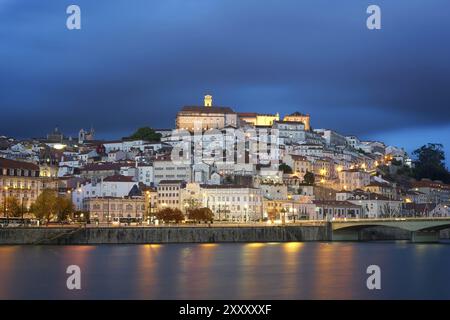 Coimbra vista della città di notte con il fiume Mondego e splendidi edifici storici, in Portogallo Foto Stock