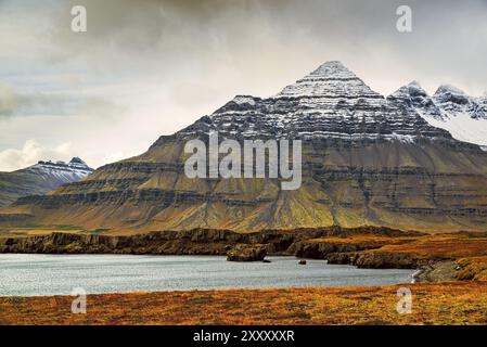 Vista sulle montagne a Stodvarfjordur, sul lato est dell'Islanda, in una giornata nuvolosa Foto Stock