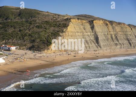 Spiaggia di Magoito con surfisti che navigano sulle onde del mare a Sintra, Portogallo, Europa Foto Stock