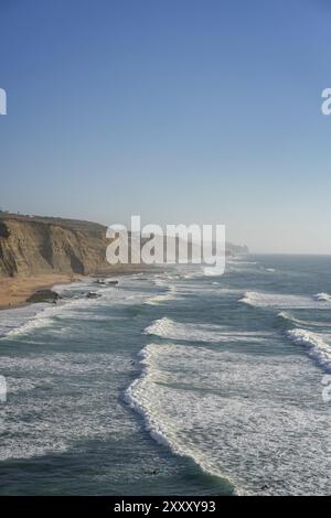 Spiaggia di Magoito con surfisti che navigano sulle onde del mare a Sintra, Portogallo, Europa Foto Stock