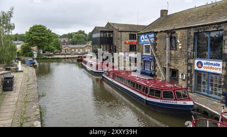 Skipton, North Yorkshire, Inghilterra, Regno Unito, 04 giugno, 2018: case e barche a remi sulla riva del canale di Leeds e Liverpool Foto Stock