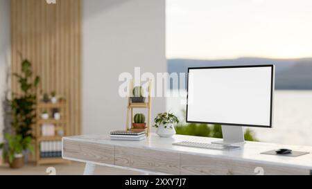 Un'immagine ravvicinata di una scrivania per computer in una camera spaziosa e moderna dal design minimalista con vista sulla natura, dotata di un computer con un modello di schermo bianco Foto Stock