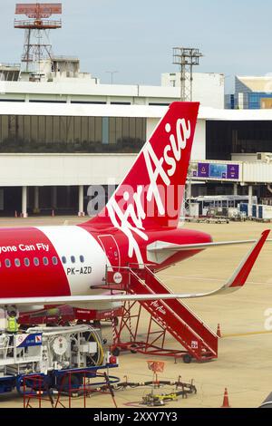 Bangkok, Thailandia, 3 novembre 2015: Scalinata parcheggiata nella sezione coda dell'aereo Red Air Asia di fronte alla torre di controllo dell'aeroporto Don Mueang. Verticale Foto Stock