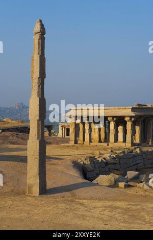 Una colonna monolitica in pietra si erge in cima a una collina tra le antiche rovine di Hampi, Karnataka, India, Asia Foto Stock