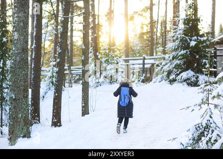 Giovane donna escursionismo in bianco inverno foresta. Il concetto di stile di vita Foto Stock