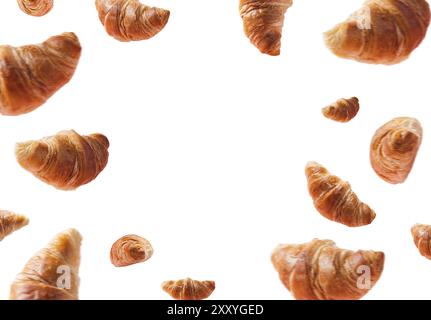 Molti croissant appena sfornati che si levitano o volano. Croissant isolati su fondo bianco con spazio copia al centro. Scena di levitazione. Panetteria, con Foto Stock