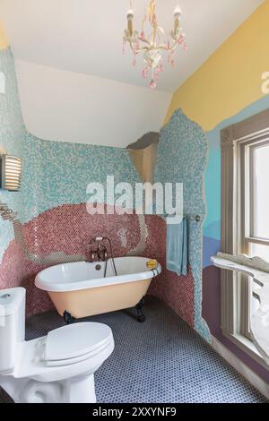 Bagno ristrutturato in una vecchia casa con motivi artistici e colori di mini piastrelle sulle pareti Foto Stock