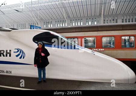 Un turista in piedi vicino a un treno proiettile in Cina. Foto Stock