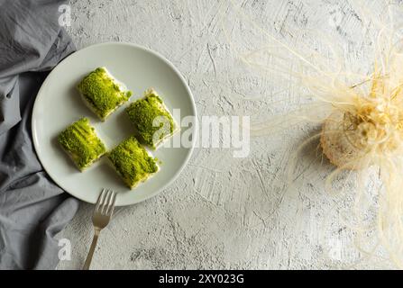 Nuovo dolce turco tradizionale baklava lattiera fredda con pistacchio su tavola rustica bianca, ramadan o dessert natalizi Foto Stock