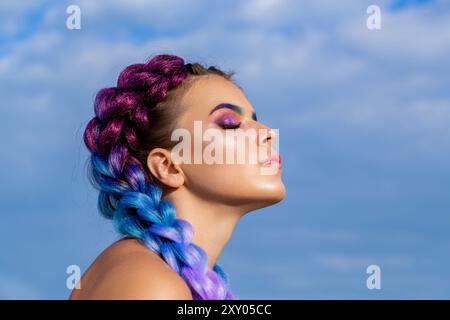 Trucco luminoso, rosa, trecce, acconciature a coda di cavallo. Ragazza colorata kanekalon intrecciata tra i capelli. Due trecce spesse di capelli colorati, un'acconciatura giovane Foto Stock