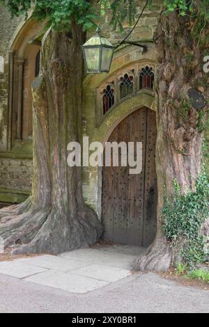 Inghilterra, Gloucestershire, Stow on the Wold, St Edward's Church, North Door fiancheggiata da alberi di tasso che si dice abbiano ispirato le porte di Durin di Tolkien in il Signore degli anelli. Foto Stock