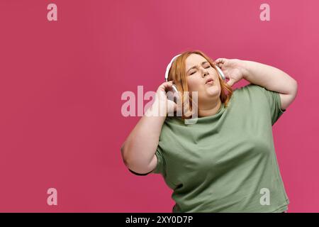 Una donna che indossa le cuffie balla con gli occhi chiusi. Foto Stock