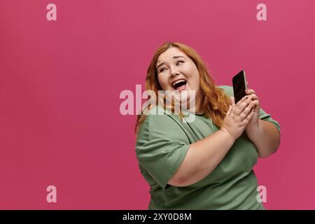 Una donna con una camicia verde ride mentre è in corso una telefonata. Foto Stock