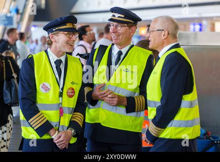 27 agosto 2024, Assia, Francoforte sul meno: Tre piloti Discover Airlines di Vereinigung Cockpit partecipano allo sciopero e si trovano al Terminal 1 dell'aeroporto Rhein-Main. Inizia lo sciopero presso la controllata Lufthansa Discover Airlines, i sindacati Vereinigung Cockpit (VC) e UFO hanno invitato gli equipaggi della giovane controllata Lufthansa a scioperare per quattro giorni fino a venerdì (agosto 30 incluso). Tutte le partenze dalla Germania sono interessate. Foto: Andreas Arnold/dpa Foto Stock