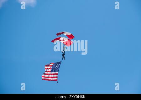 Paracadutista canadese con bandiera canadese e americana. Abbotsford, Canada BC, Abbotsford Airshow 2023. Il Canadian International Air Show nel Nord America Foto Stock