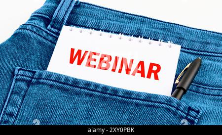 Parole DEL WEBINAR scritte su un taccuino in lettere rosse in jeans Foto Stock