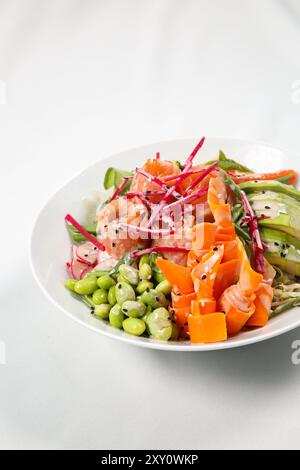 Ciotola hawaiana con salmone, avocado, ravanello, fagioli di edamame, cavolo rosso. Salsa di soia, lime e salsa di sesamo. tavolo bianco Foto Stock