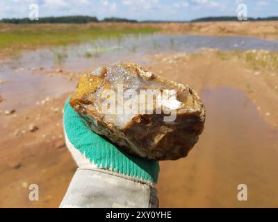 Grande frammento di calcedonia bagnata in mano, scoppio, foto di campo Foto Stock