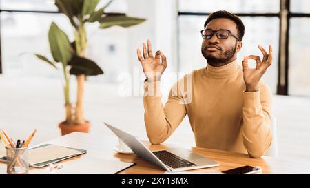 Calma ragazzo nero meditando mentre si fanno i compiti Foto Stock