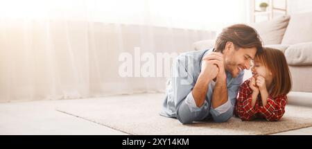 Bel papà e la sua ragazza liitle che si stesa sul pavimento Foto Stock